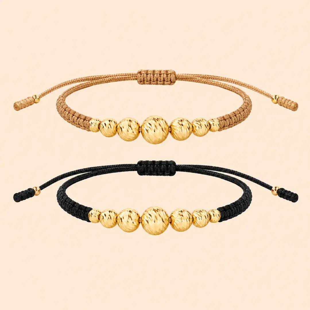 Dos manillas tejidas con esferas en oro 18K, una en cordón beige y otra en cordón negro